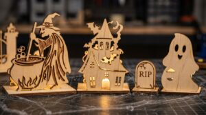 Laser cut wooden candle holders: a witch with a cauldron, a haunted house, a RIP tombstone and a ghost