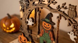 Pumpkin-head scarecrow on a swing next to a glowing jack-o-lantern