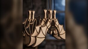 Close-up of laser cut plywood bats hanging from threads